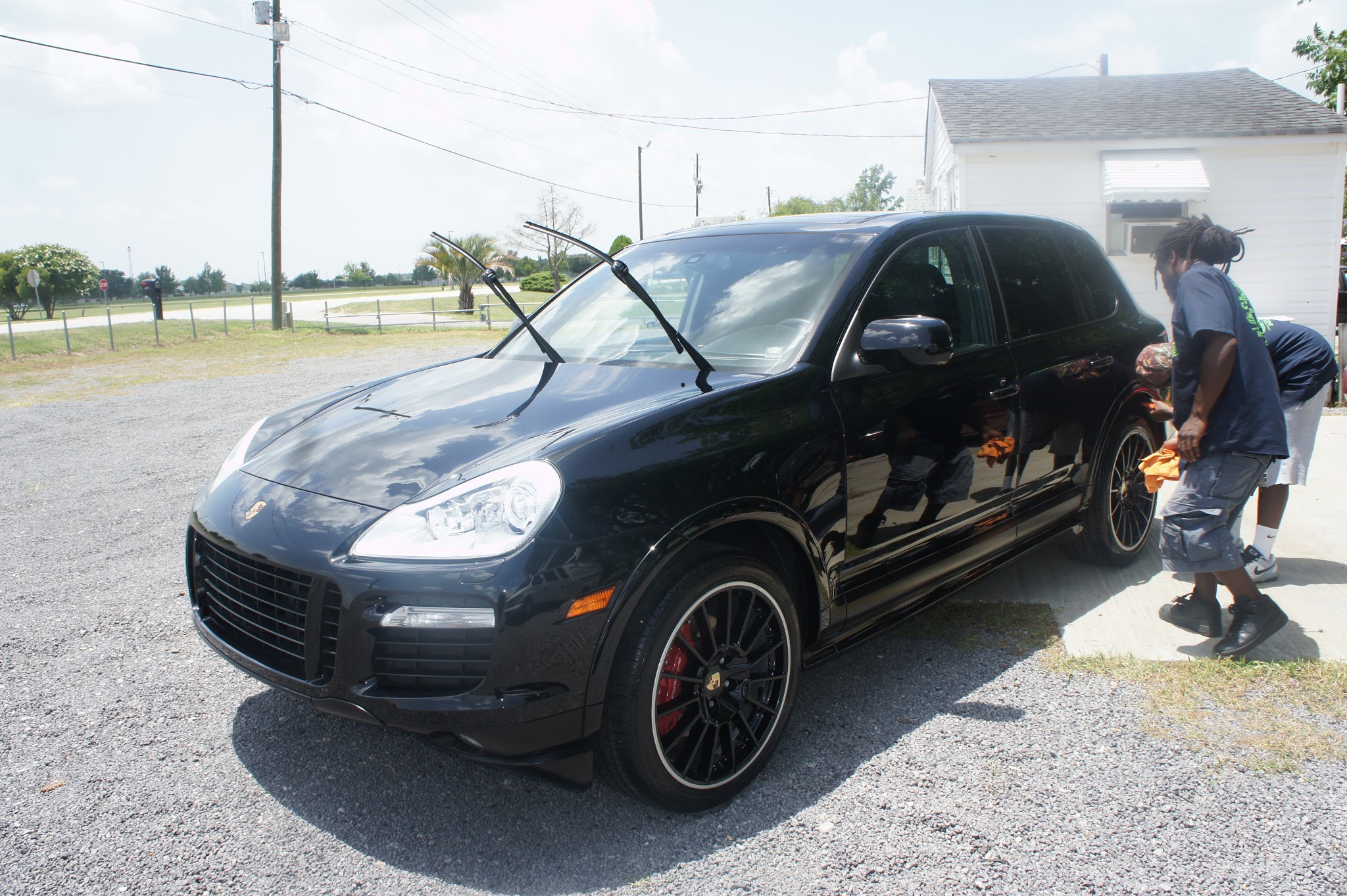 Black Porsche being hand dried in the sun