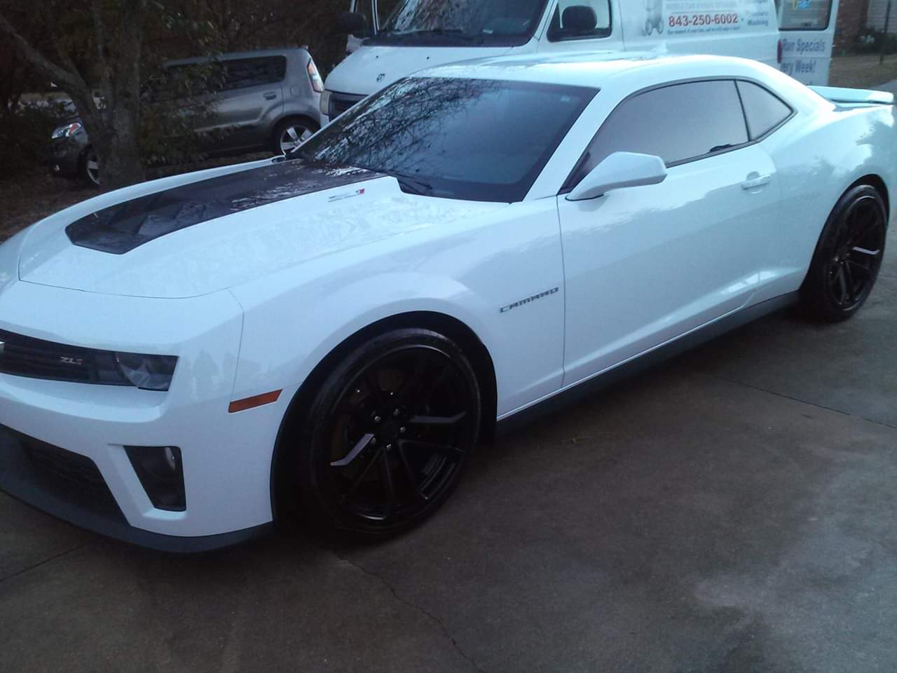 White Camaro with black wheels after a wash